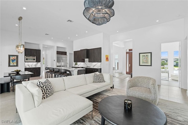 living room with light tile patterned floors, a chandelier, visible vents, and recessed lighting