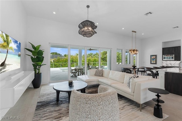living area with recessed lighting, an inviting chandelier, a high ceiling, and plenty of natural light