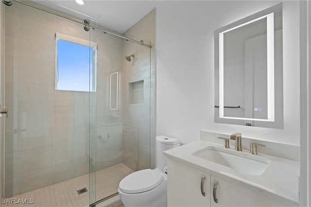 bathroom with a stall shower, vanity, and toilet