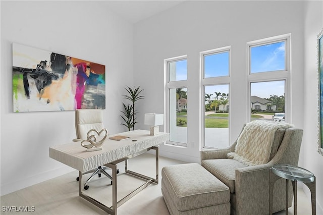 office space featuring a high ceiling and baseboards