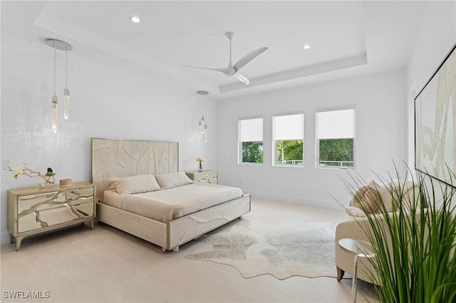 bedroom with recessed lighting, a raised ceiling, and baseboards