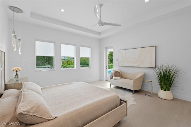 bedroom with recessed lighting, wood finished floors, baseboards, and access to outside