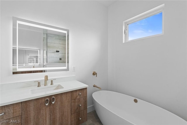 bathroom with tile patterned floors, vanity, and a freestanding bath
