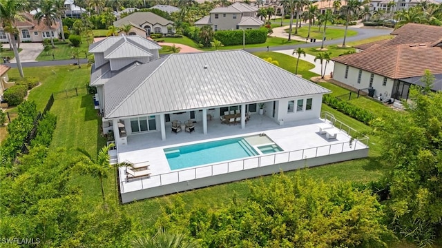 rear view of house featuring a patio area, a fenced backyard, a residential view, and metal roof