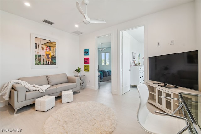 living area with a ceiling fan, visible vents, and recessed lighting