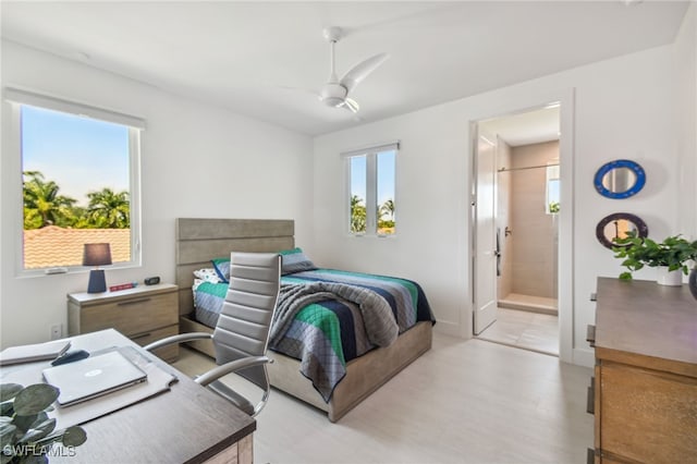bedroom featuring ensuite bath, a ceiling fan, and light wood-style floors