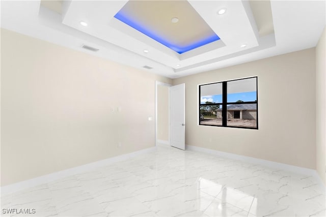 unfurnished room featuring a tray ceiling, baseboards, visible vents, and recessed lighting