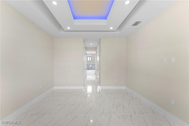 unfurnished room featuring baseboards, recessed lighting, visible vents, a tray ceiling, and marble finish floor