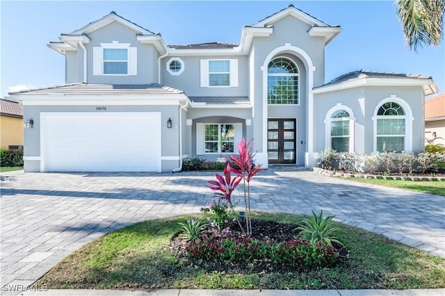 14696 Indigo Lakes Cir, Naples, FL 34119 - view of front of property with stucco siding, decorative driveway, a garage, and french doors