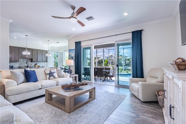 14696 Indigo Lakes Cir, Naples, FL 34119 - living area featuring a ceiling fan, crown molding, wood finished floors, visible vents, and recessed lighting