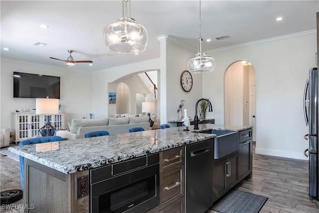 14696 Indigo Lakes Cir, Naples, FL 34119 - kitchen featuring arched walkways, a sink, built in microwave, visible vents, and dishwasher
