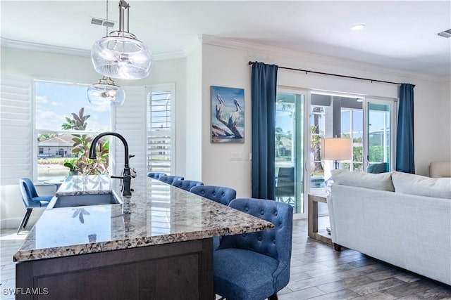 14696 Indigo Lakes Cir, Naples, FL 34119 - bar with a sink, visible vents, wood finished floors, crown molding, and hanging light fixtures
