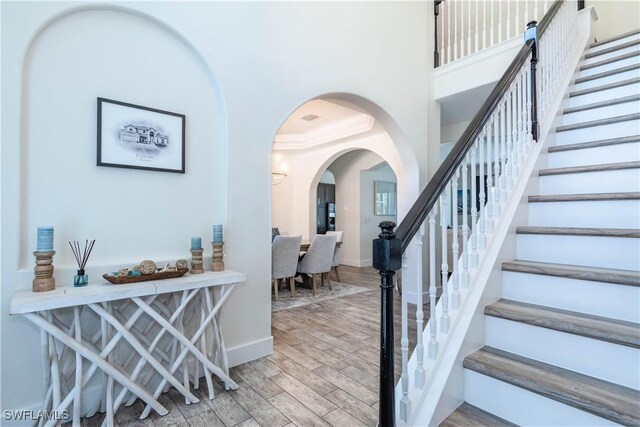 14696 Indigo Lakes Cir, Naples, FL 34119 - entryway featuring wood finished floors, baseboards, arched walkways, and stairs