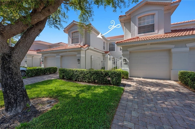 2165 Arielle Dr Unit 1605, Naples, FL 34109 - mediterranean / spanish-style house featuring decorative driveway, a tiled roof, and an attached garage