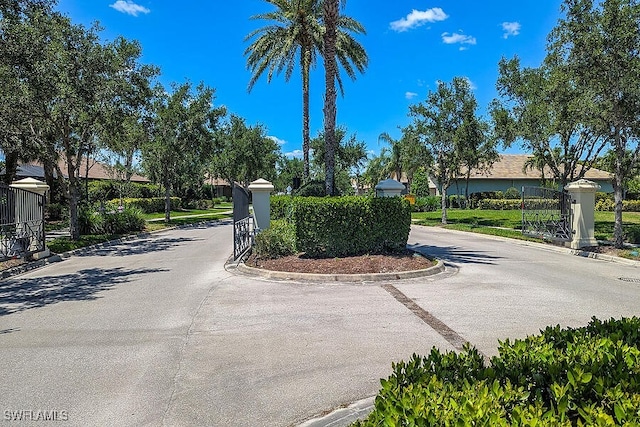 view of road with curbs and a gated entry