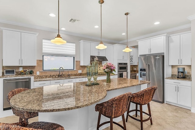 kitchen featuring a sink, visible vents, appliances with stainless steel finishes, and a kitchen bar