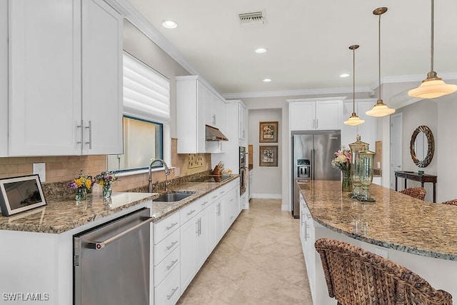 kitchen with crown molding, stone counters, white cabinets, stainless steel appliances, and backsplash