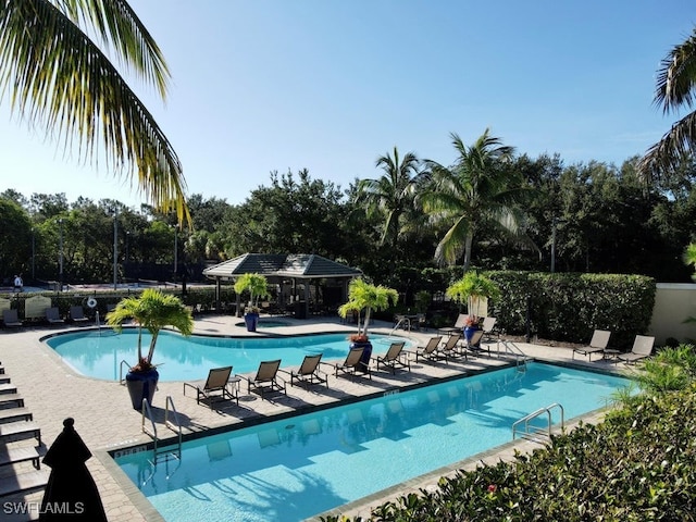 community pool featuring a patio area and fence