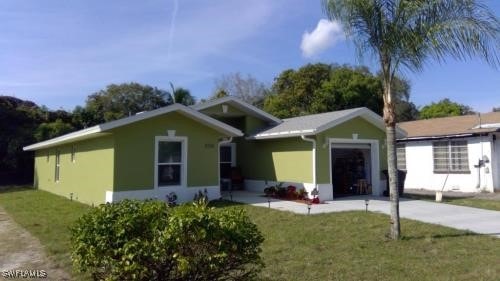 single story home featuring an attached garage, driveway, and a front lawn
