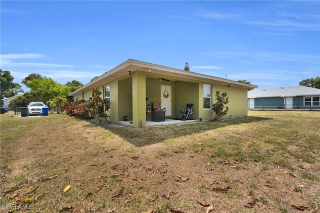 1938 Lillie St, Fort Myers, FL 33916 - back of house with stucco siding, a patio, a lawn, and a ceiling fan