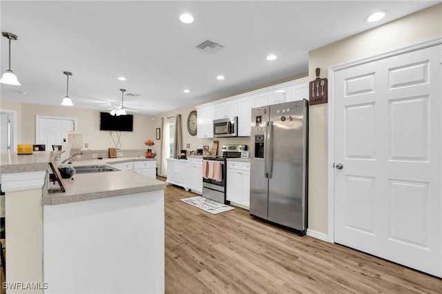 1938 Lillie St, Fort Myers, FL 33916 - kitchen with stainless steel appliances, a sink, light wood-style floors, white cabinetry, and recessed lighting