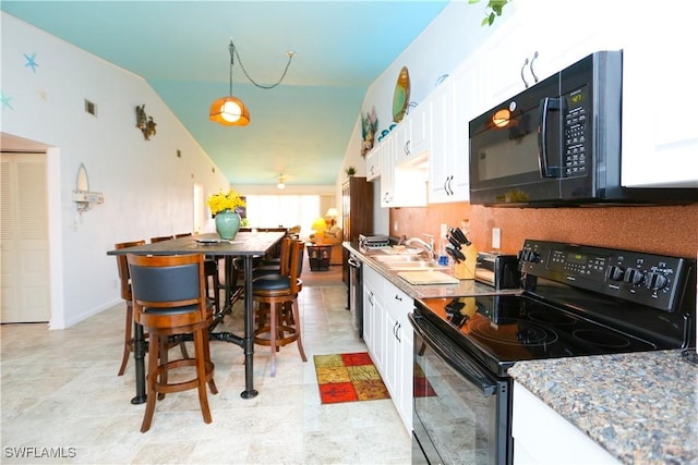4030 Northlight Dr, Naples, FL 34112 - kitchen with white cabinets, a sink, black appliances, and tasteful backsplash
