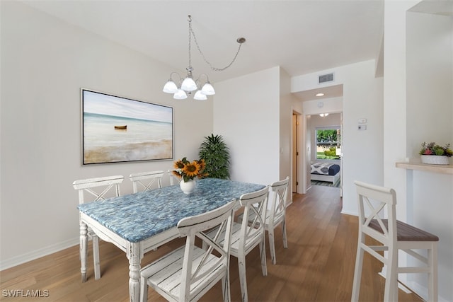 6560 Huntington Lakes Cir Unit 102, Naples, FL 34119 - dining space with a chandelier, wood finished floors, baseboards, and visible vents
