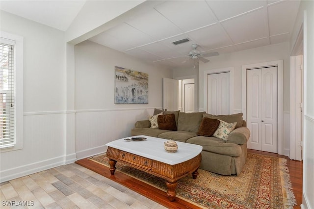 living area featuring a healthy amount of sunlight, light wood-style floors, and visible vents