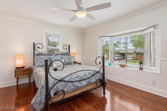 bedroom with wood finished floors, crown molding, baseboards, and multiple windows
