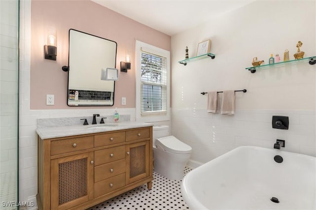full bathroom with tile walls, a soaking tub, a wainscoted wall, and toilet
