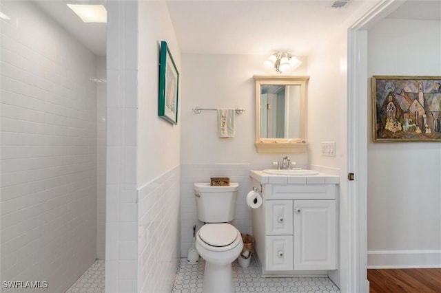 bathroom featuring tiled shower, vanity, and toilet