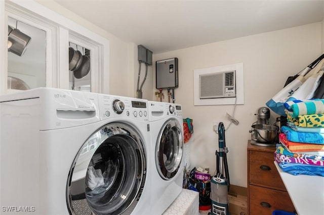 washroom featuring a wall mounted air conditioner, washer and clothes dryer, and laundry area