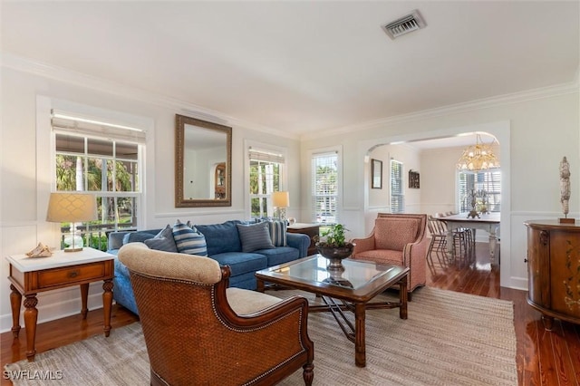 interior space with arched walkways, a chandelier, visible vents, and plenty of natural light