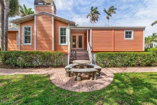 rear view of house with a yard, french doors, and a patio