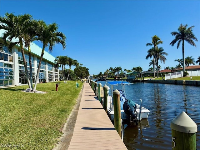 view of dock with a water view and a lawn