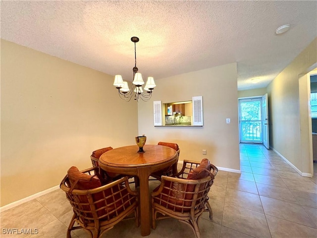 tiled dining room with baseboards, a chandelier, and a textured ceiling