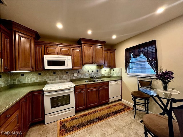 kitchen featuring a sink, tasteful backsplash, recessed lighting, and white appliances