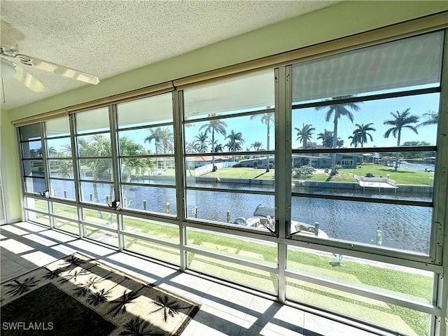 details with a water view, a ceiling fan, and a textured ceiling