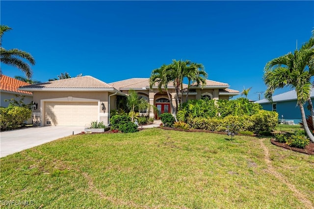 211 Lido Dr, Punta Gorda, FL 33950 - view of front of property featuring a tiled roof, a front yard, an attached garage, french doors, and driveway