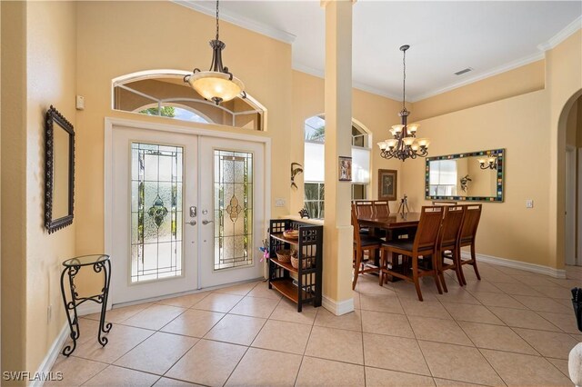 211 Lido Dr, Punta Gorda, FL 33950 - foyer featuring a notable chandelier, baseboards, light tile patterned floors, french doors, and crown molding