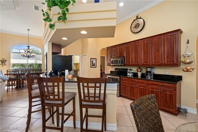 211 Lido Dr, Punta Gorda, FL 33950 - kitchen featuring arched walkways, a notable chandelier, dark countertops, appliances with stainless steel finishes, and light tile patterned flooring