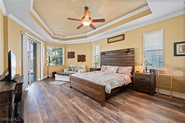 211 Lido Dr, Punta Gorda, FL 33950 - bedroom featuring baseboards, a raised ceiling, crown molding, wood finished floors, and access to exterior