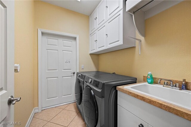 211 Lido Dr, Punta Gorda, FL 33950 - laundry room featuring light tile patterned floors, a sink, washer and dryer, baseboards, and cabinet space