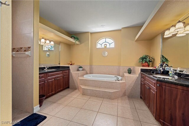 211 Lido Dr, Punta Gorda, FL 33950 - bathroom with two vanities, a bath, a sink, and tile patterned flooring