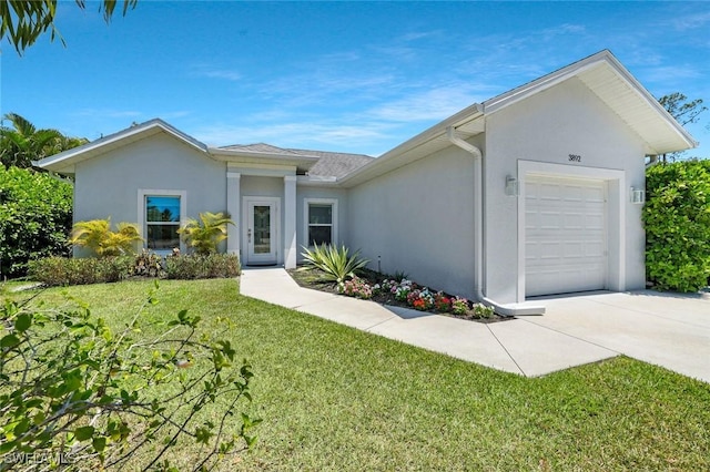 ranch-style home featuring an attached garage, concrete driveway, stucco siding, and a front yard