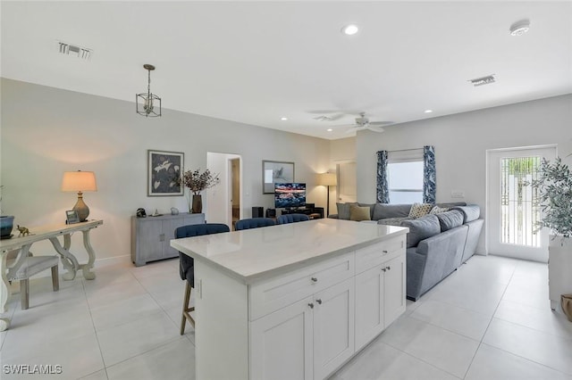 kitchen featuring open floor plan, light countertops, a ceiling fan, and light tile patterned floors