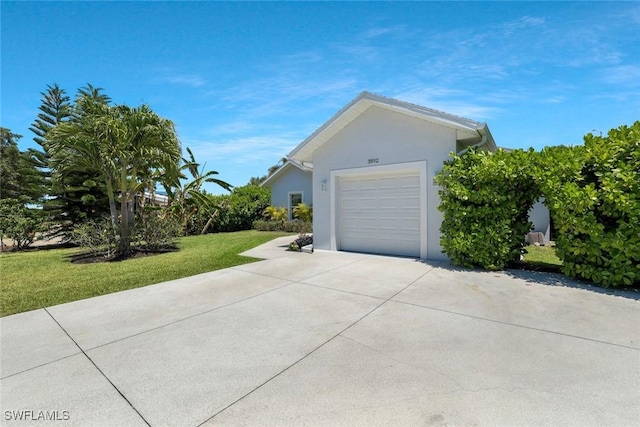 view of side of property with concrete driveway, a yard, stucco siding, and a garage