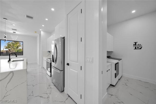 kitchen with visible vents, white cabinets, appliances with stainless steel finishes, marble finish floor, and a sink