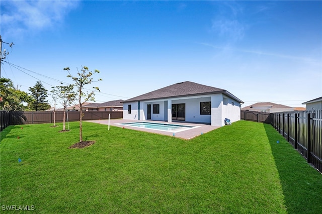 back of property with a yard, a fenced backyard, stucco siding, and a patio area