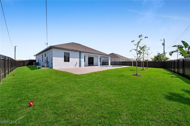 back of property featuring a yard, a fenced backyard, and a patio